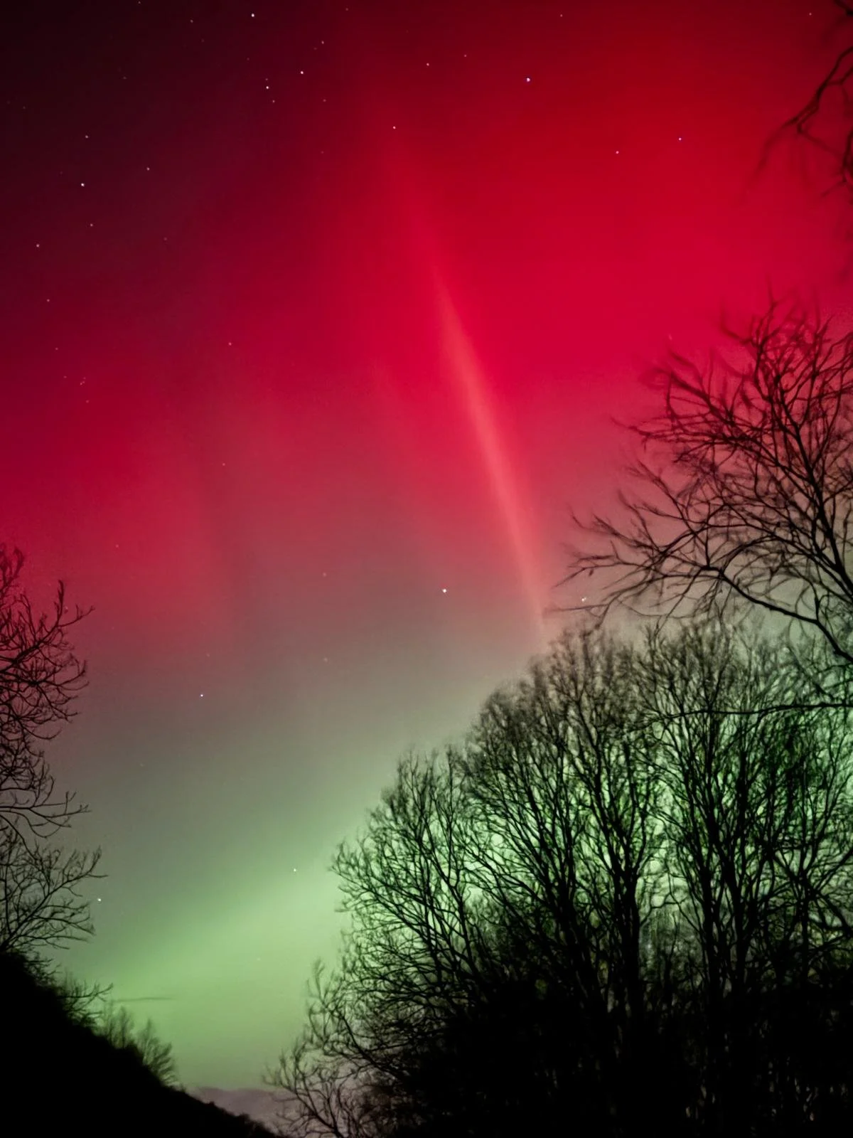 Vertical red Aurora Borealis stretching across the sky above Figgjo, Norway