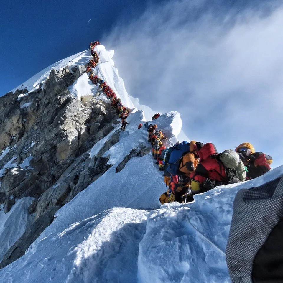 Long line of climbers ascending the narrow summit ridge near the Hillary Step on Mount Everest during the spring climbing season.