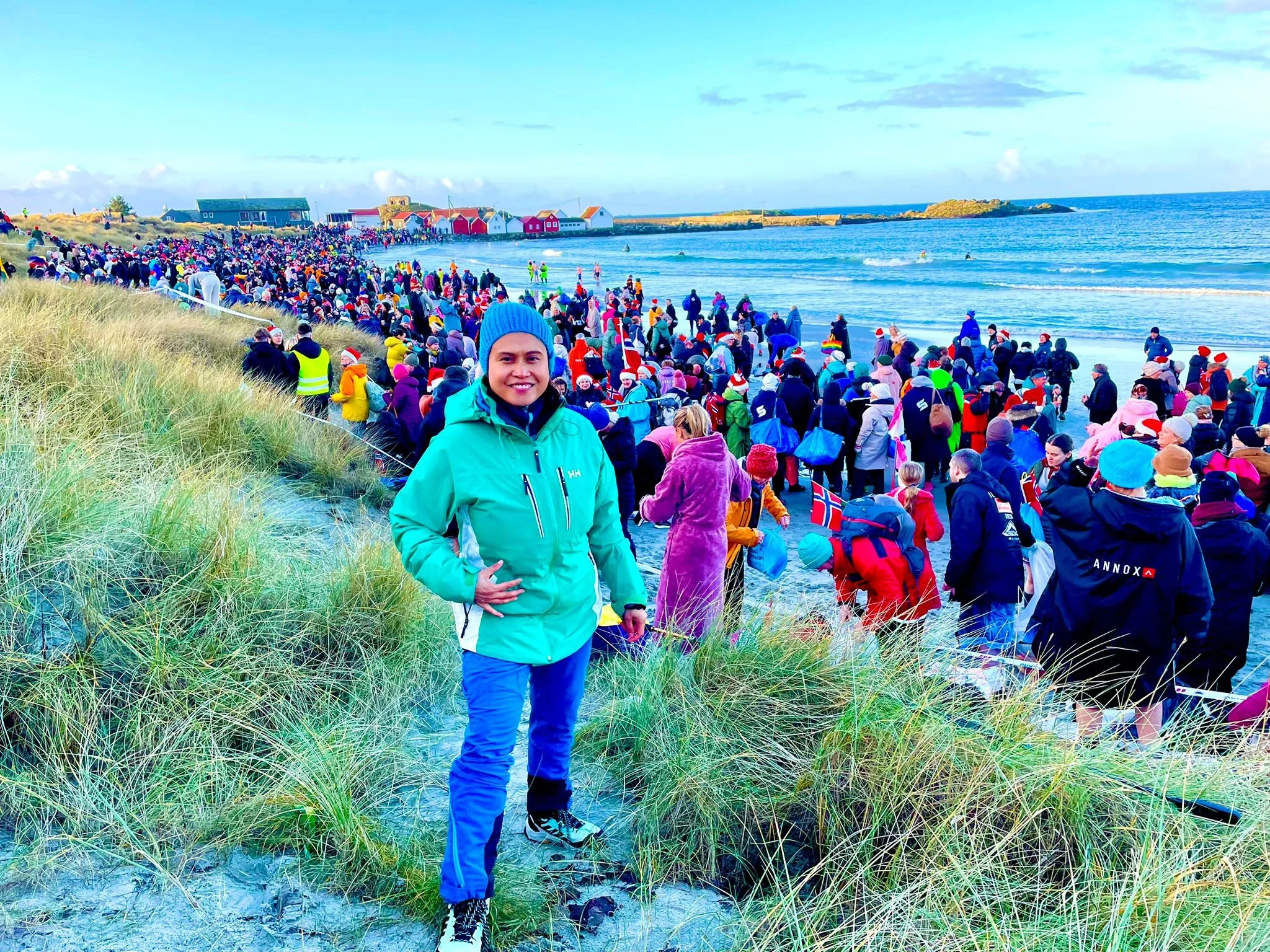 I stand on the dunes at Ølbergstranden overlooking the massive crowd gathering for Norway’s 2025 Guinness World Record Polar Bear Dip.