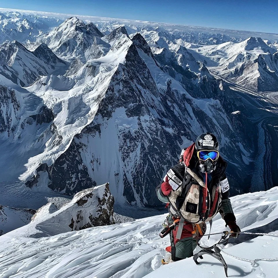 Nirmal "Nimsdai" Purja climbing a steep snow-covered Himalayan mountain while wearing supplemental oxygen during a high-altitude Project Possible expedition.