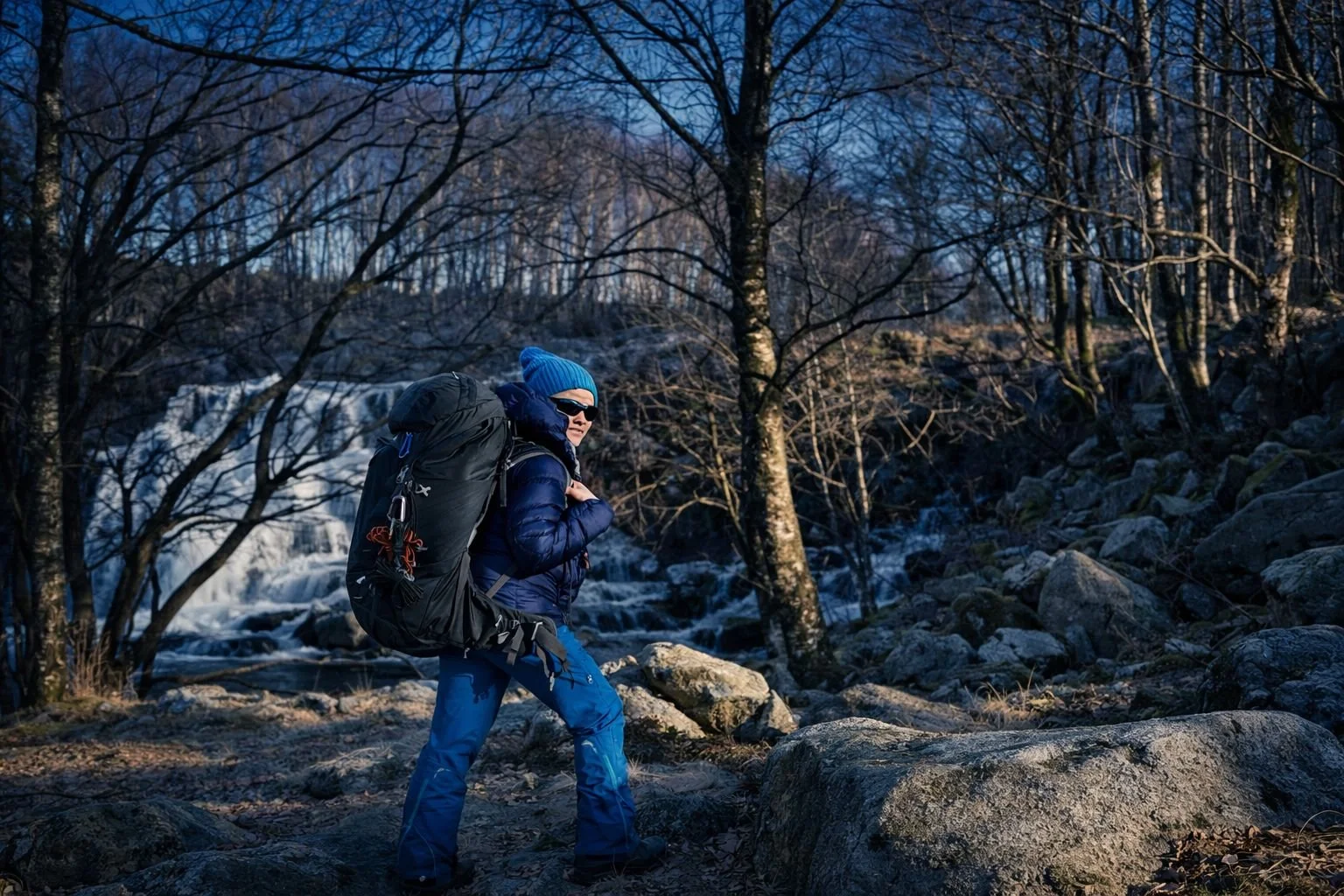 : April Alfarnes wearing blue hiking gear with Bergans backpack at Sviland Falls in Sandnes