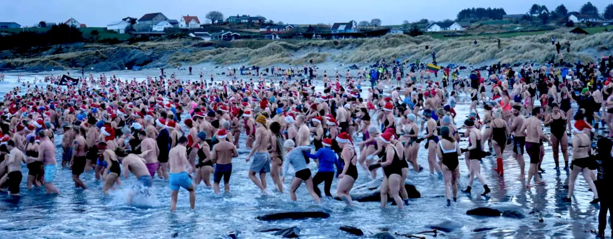 Participants rush into the icy 9.9°C water at Ølbergstranden during Norway’s 2025 Guinness World Record Polar Bear Dip.