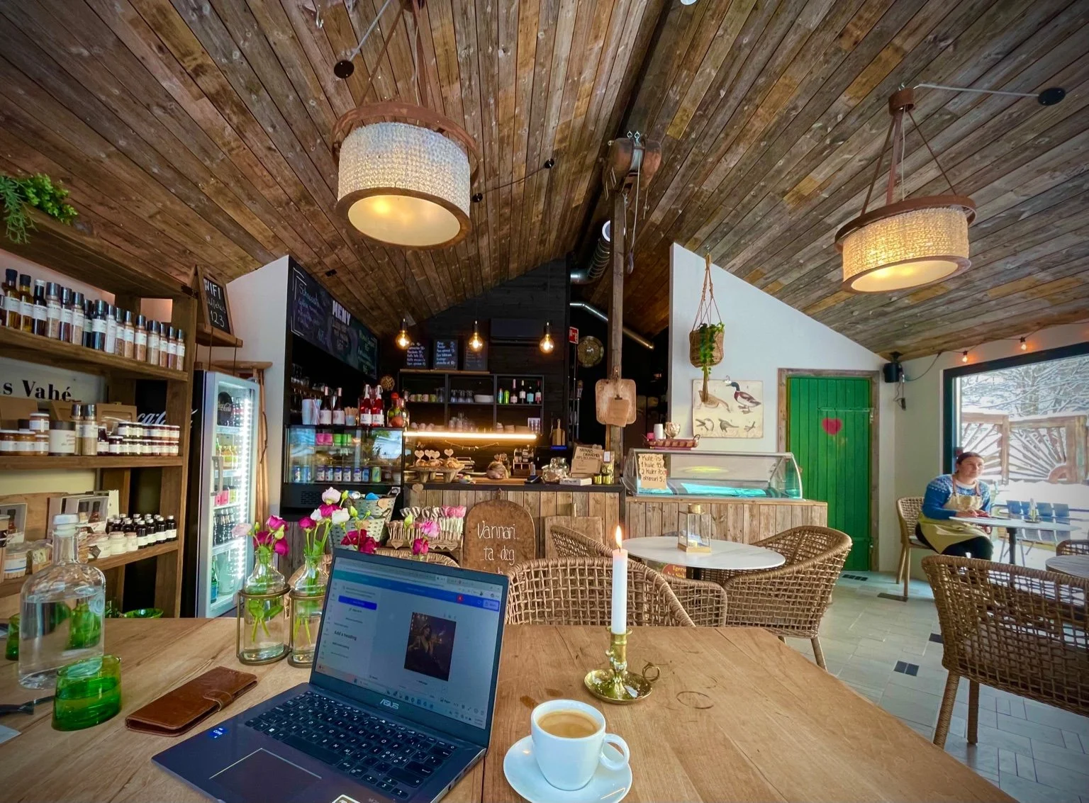 Rustic interior of Krokkus Kafé in winter with a laptop and coffee on a wooden table