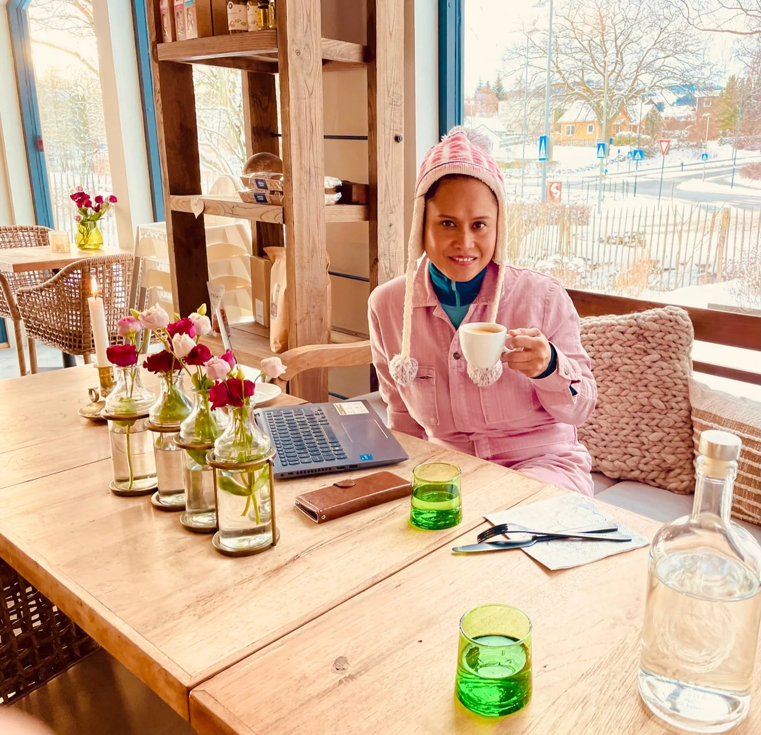 April Joy Alfarnes sitting at Krokkus Kafé holding a cup of coffee