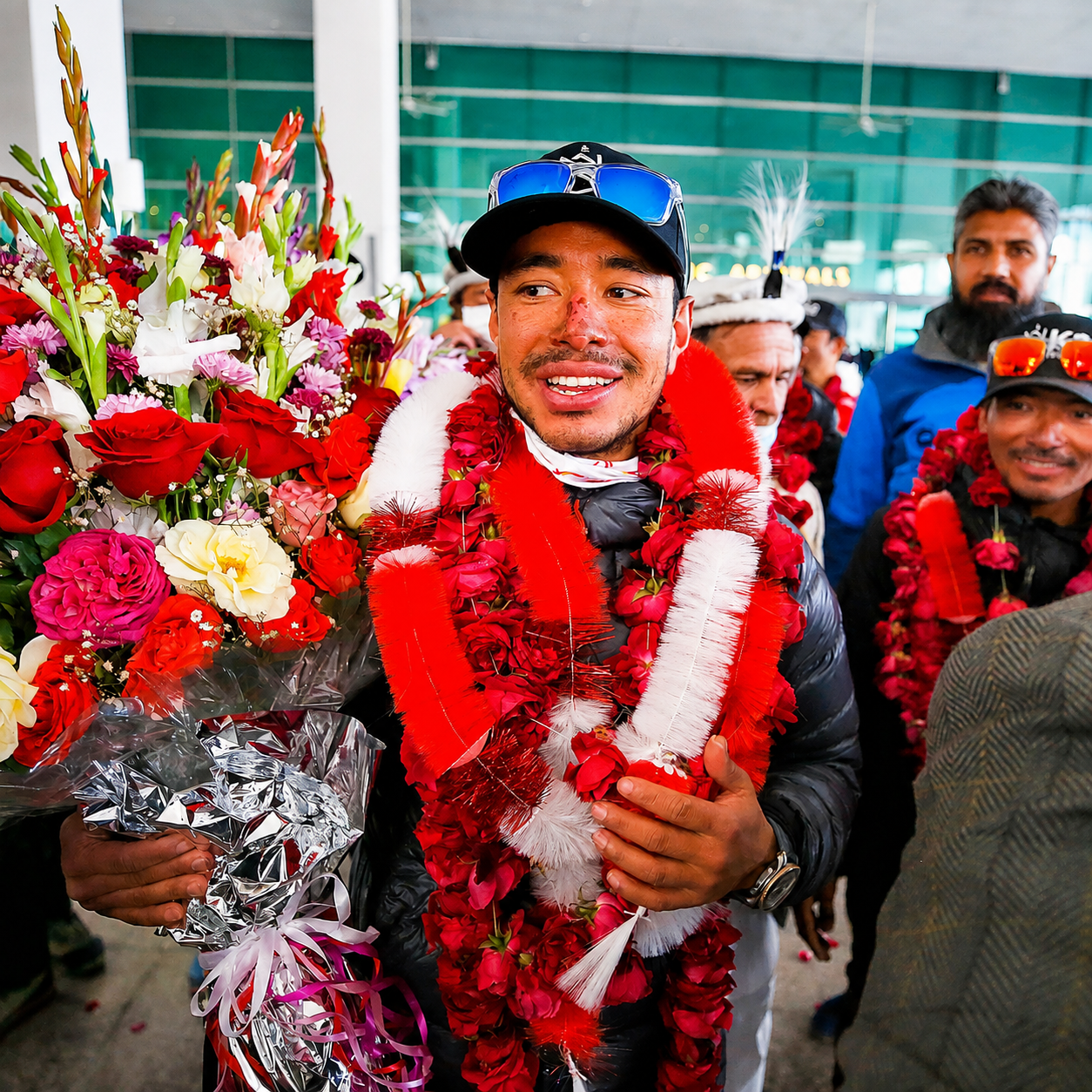 Nimsdai receives flower garlands and a bouquet during his homecoming celebration in Nepal following a successful mountaineering expedition.