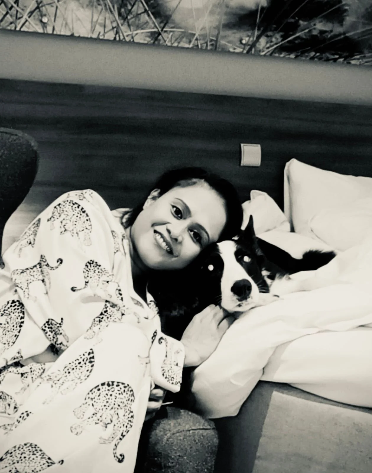 April Joy Alfarnes cuddling her Border Collie inside a Scandic Stavanger Airport hotel room during a New Year’s Eve stay.