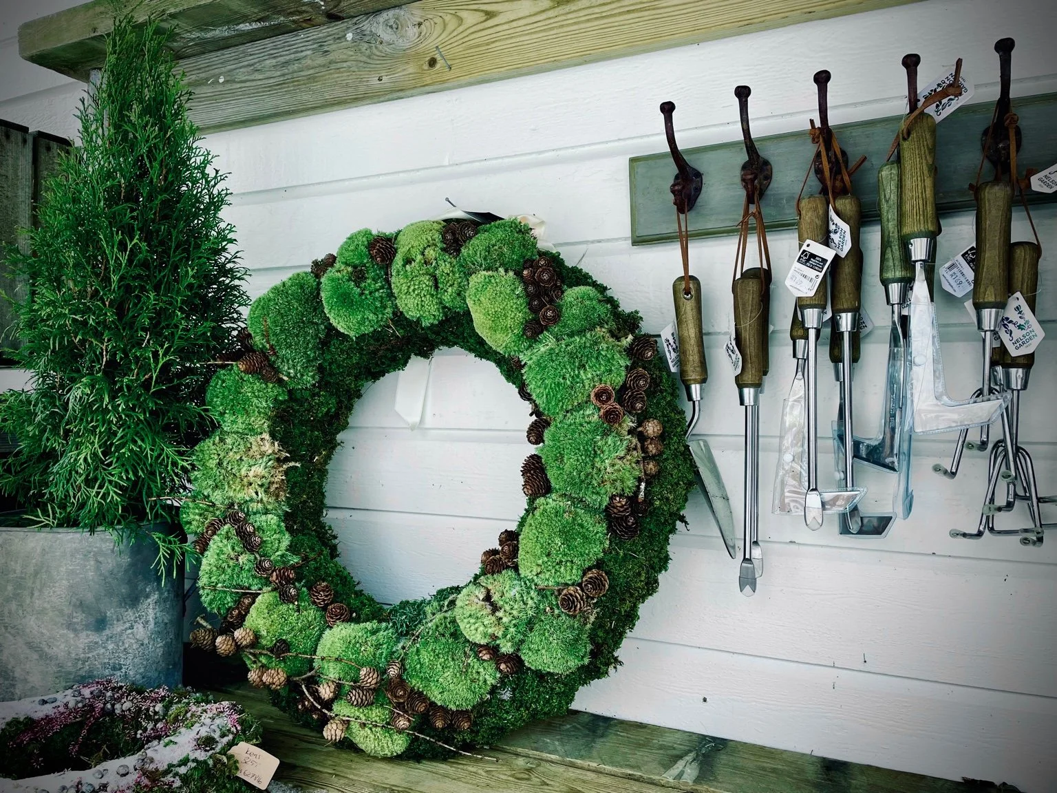 Handmade winter wreaths and gardening tools outside Krokkus Kafé