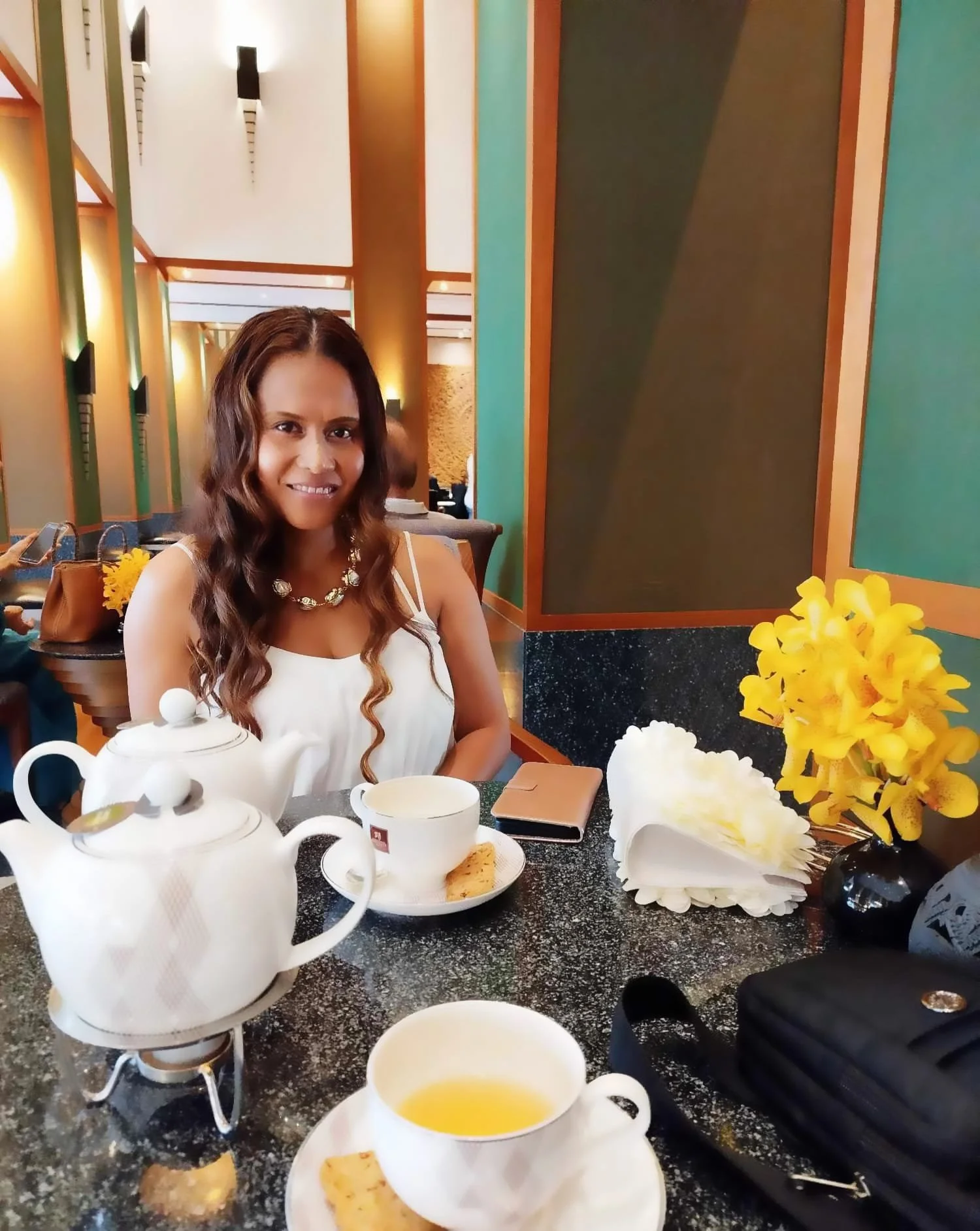 April Joy Alfarnes enjoying afternoon tea at The Sukhothai Hotel in Bangkok, highlighting the hotel’s elegant design and serene luxury atmosphere.