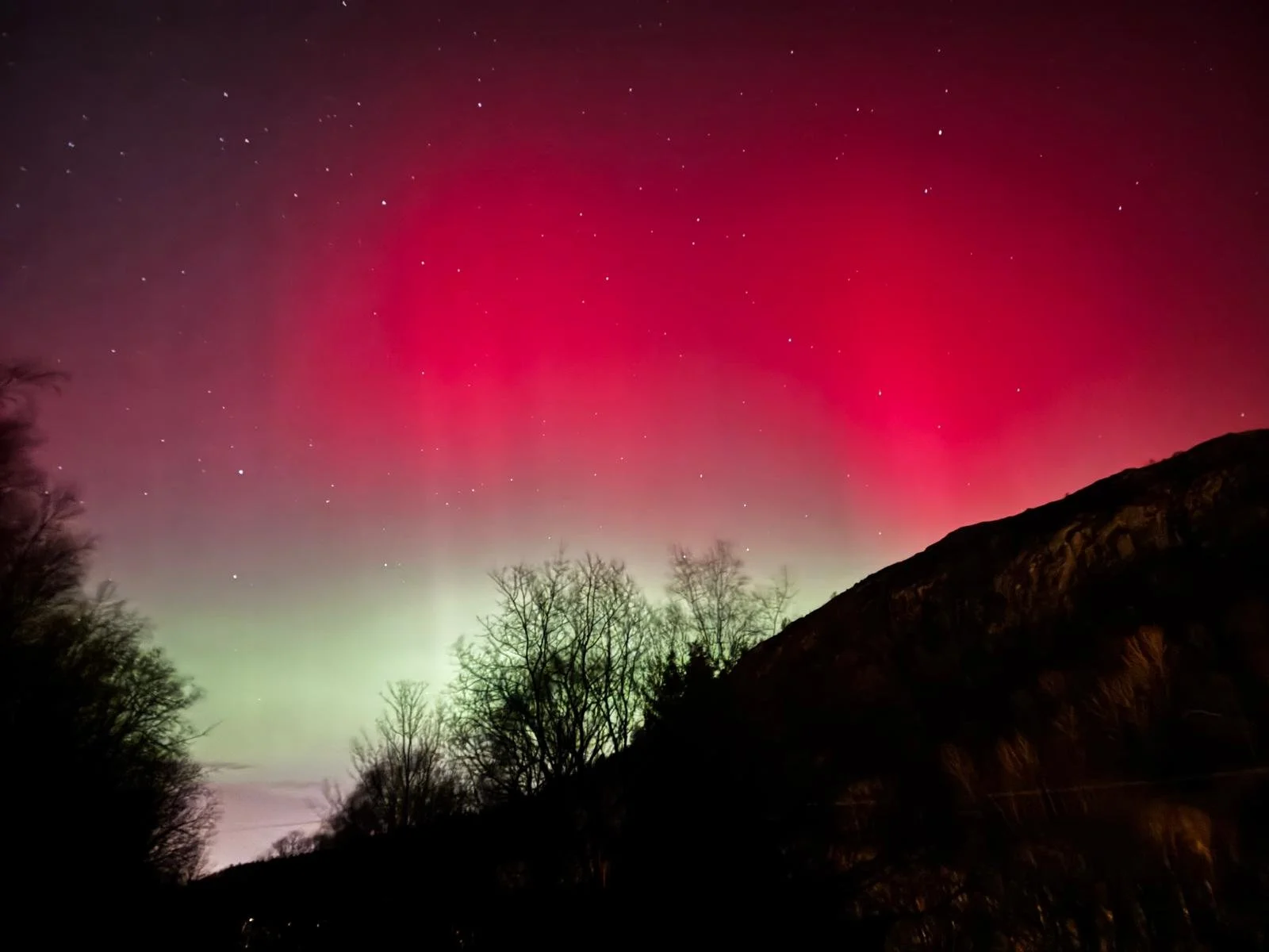 Red Aurora Borealis over Figgjo, Norway, lighting the night sky with rare crimson tones