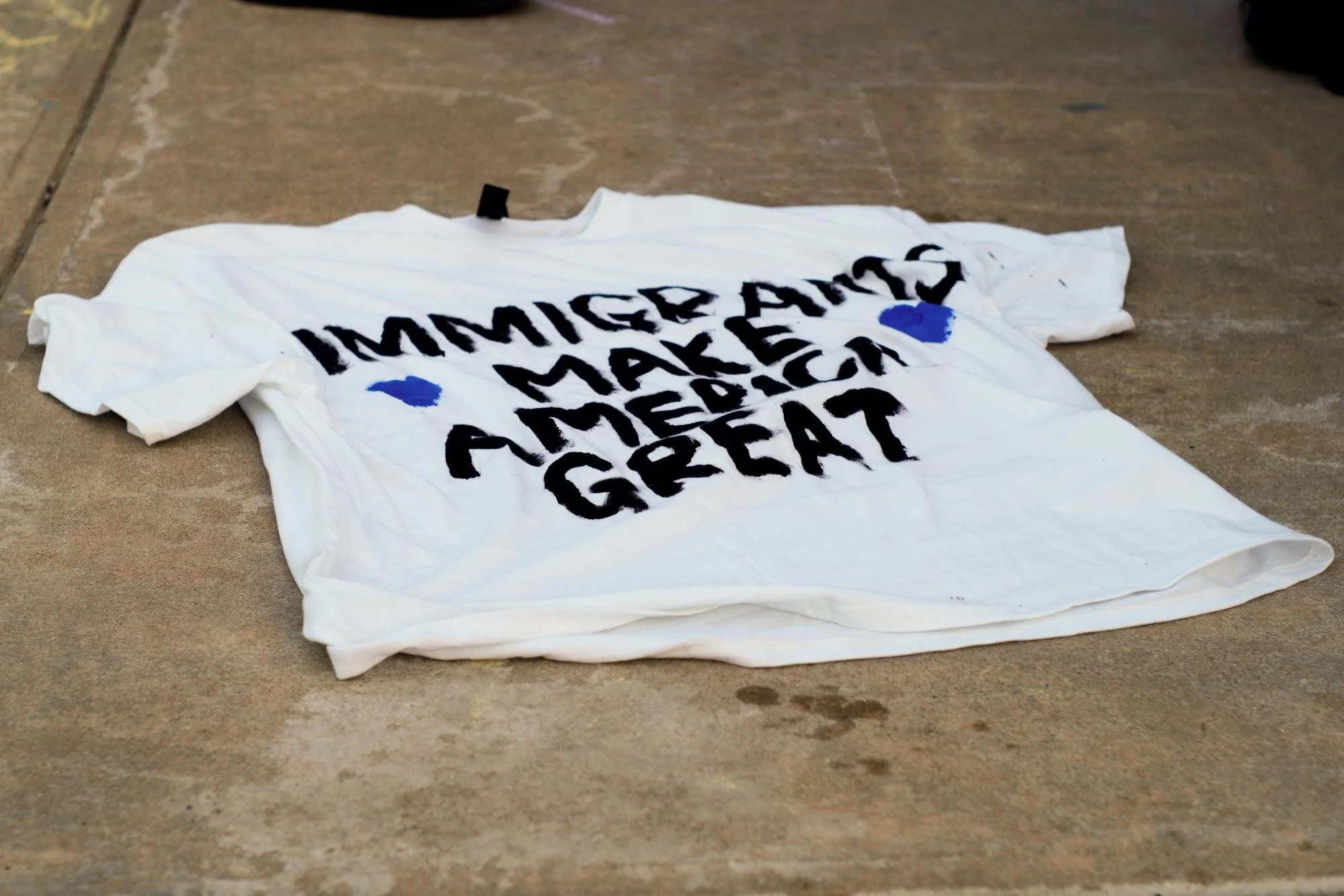  A custom-made “Immigrants Make America Great” shirt lays on the ground in front of the Owl Statue. Thursday, Feb 5, 2026. (Photographer: Nick DiCicco) 