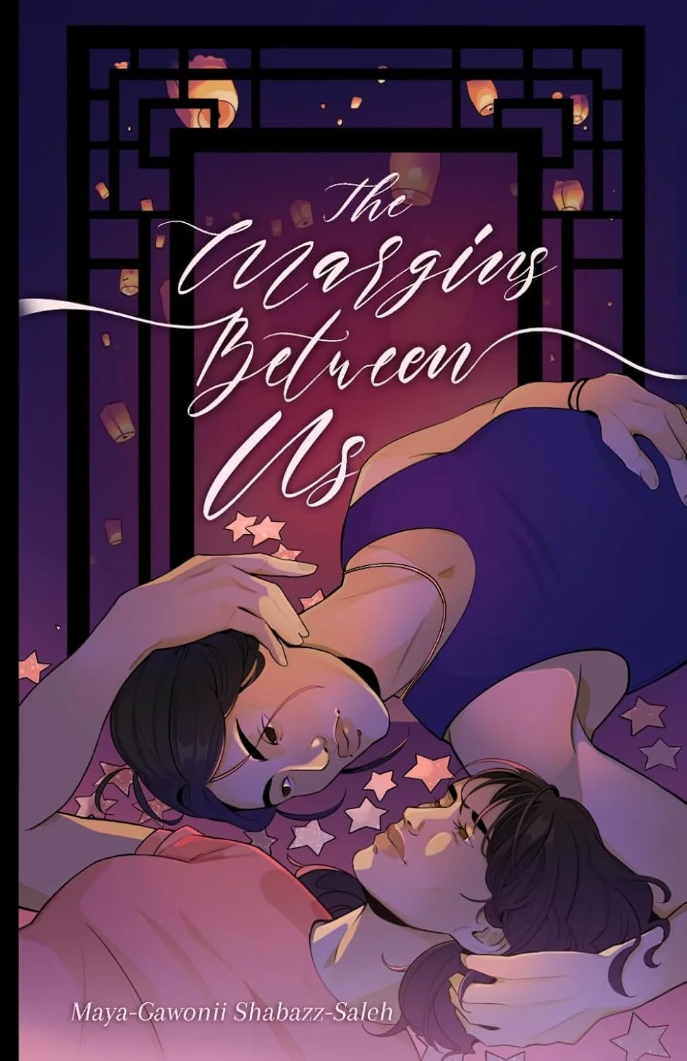 Two women with dark hair leaning toward each other at a table illuminated by paper lanterns, with a starry night sky in the background, and the text 'the margins between us'