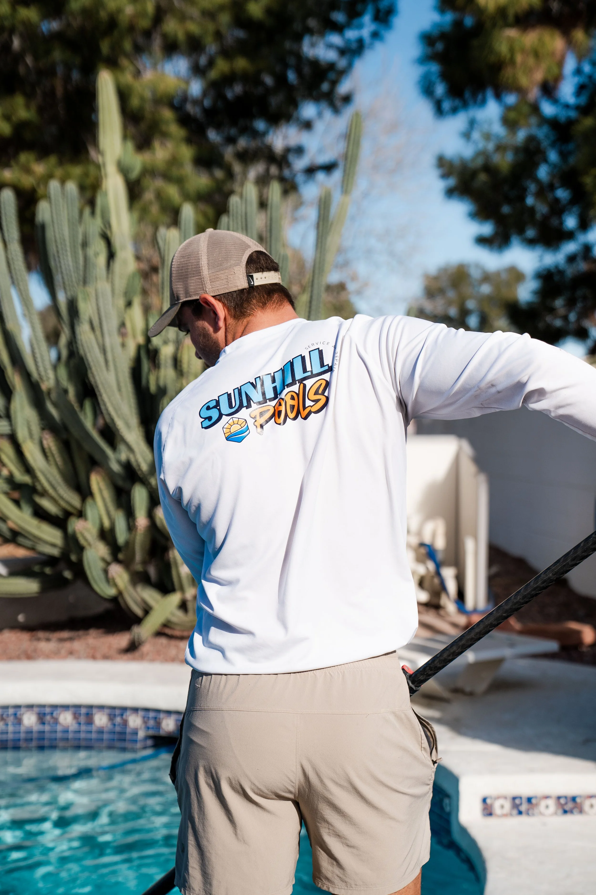 pool tech in surprise Arizona servicing a pool and skimming the leaves