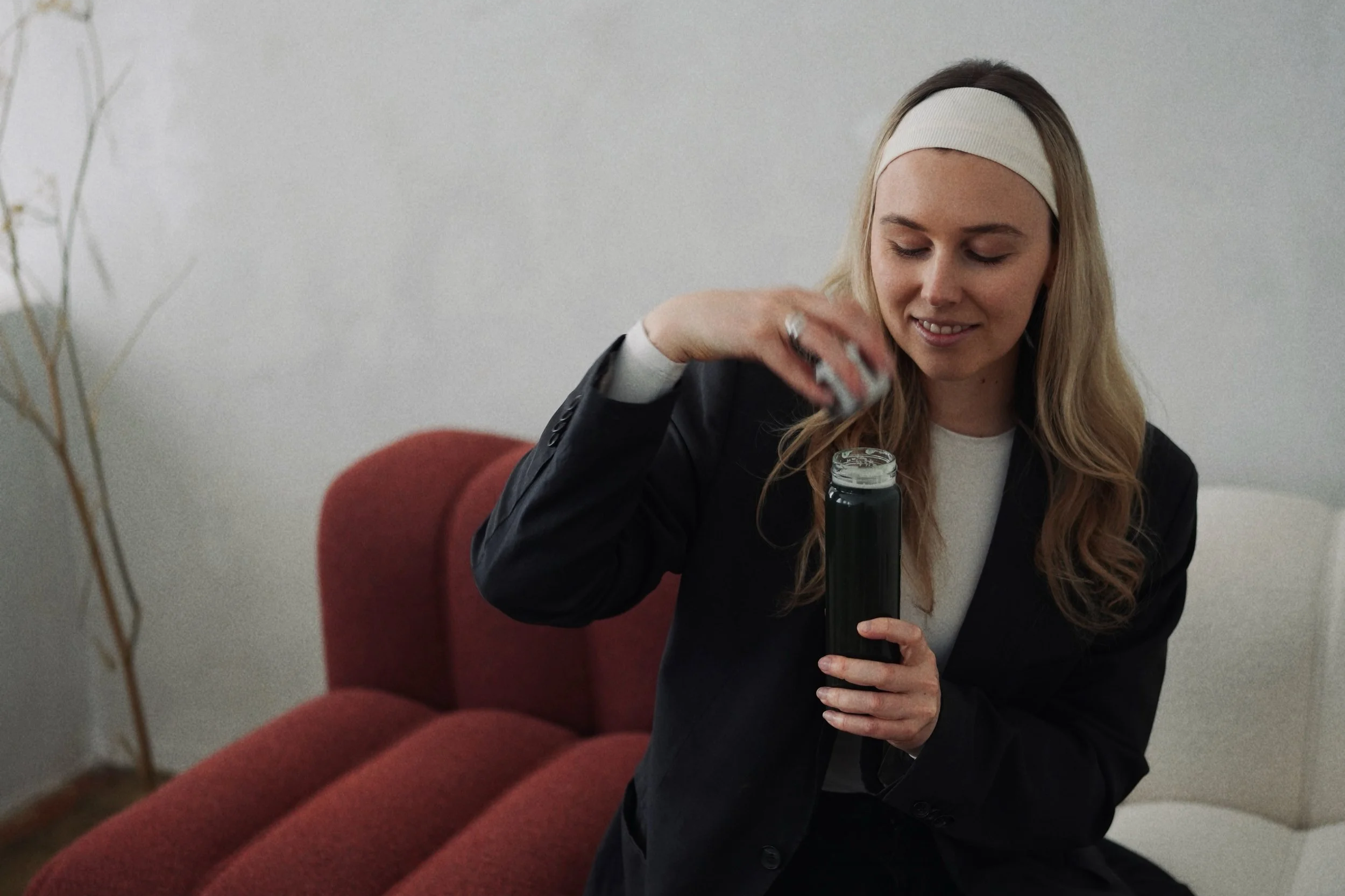 Two dessert cups filled with mashed potatoes topped with green herbs and drizzled with dark gravy, on a dark table with white placemats.