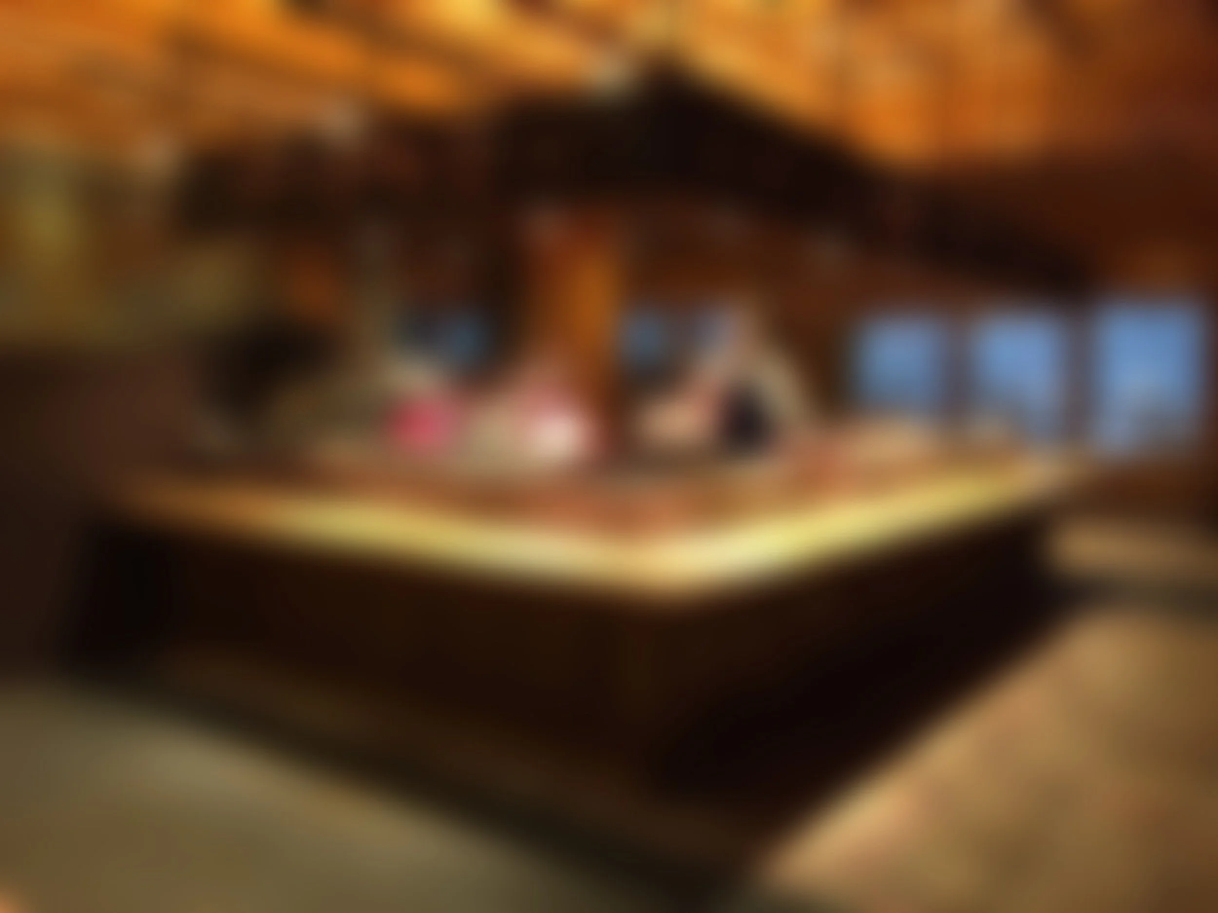 Imagen borrosa de un interior con una mesa y ventanas al fondo