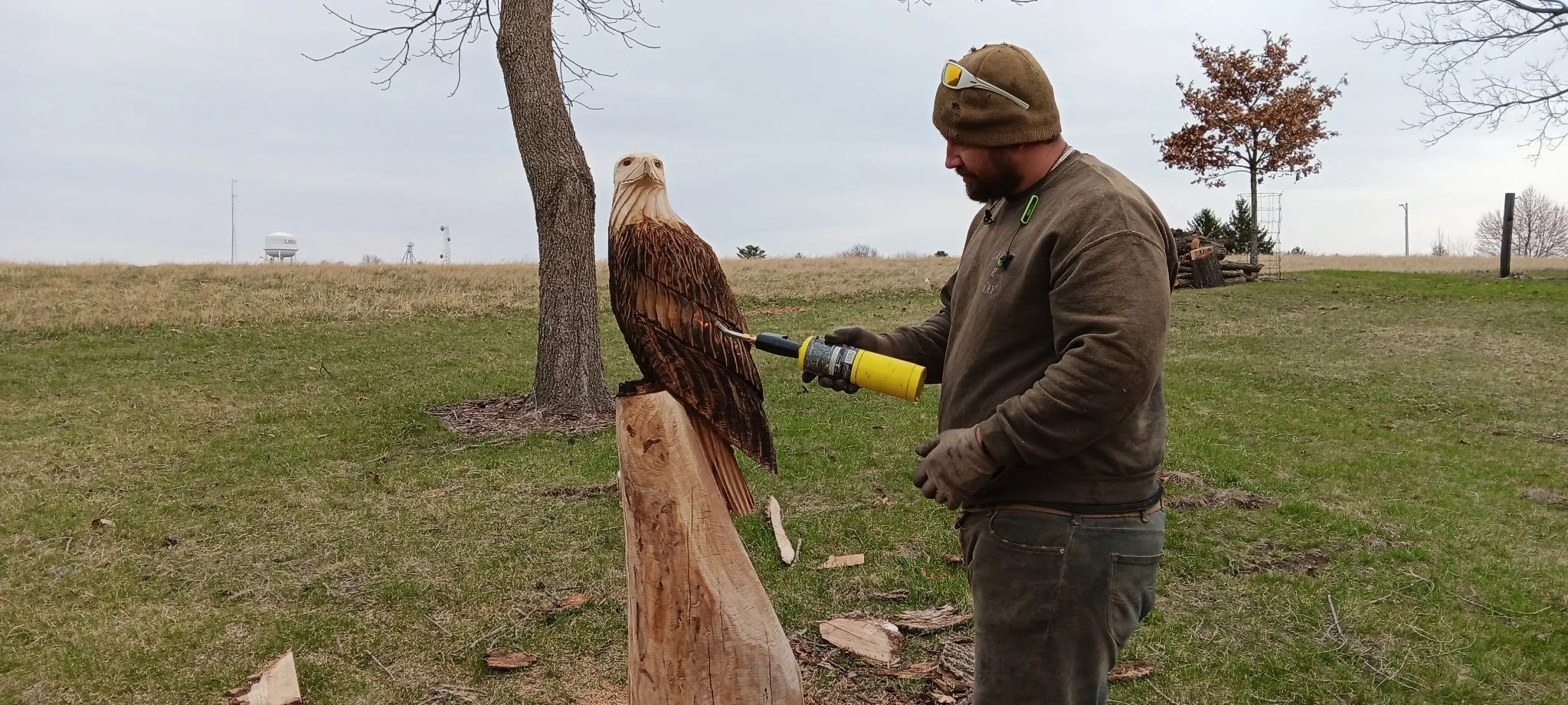 2026-4-1 Clint Henik of Carv R Way carving eagle at Pleasant Grove Heritage Park in Lisbon, IA.