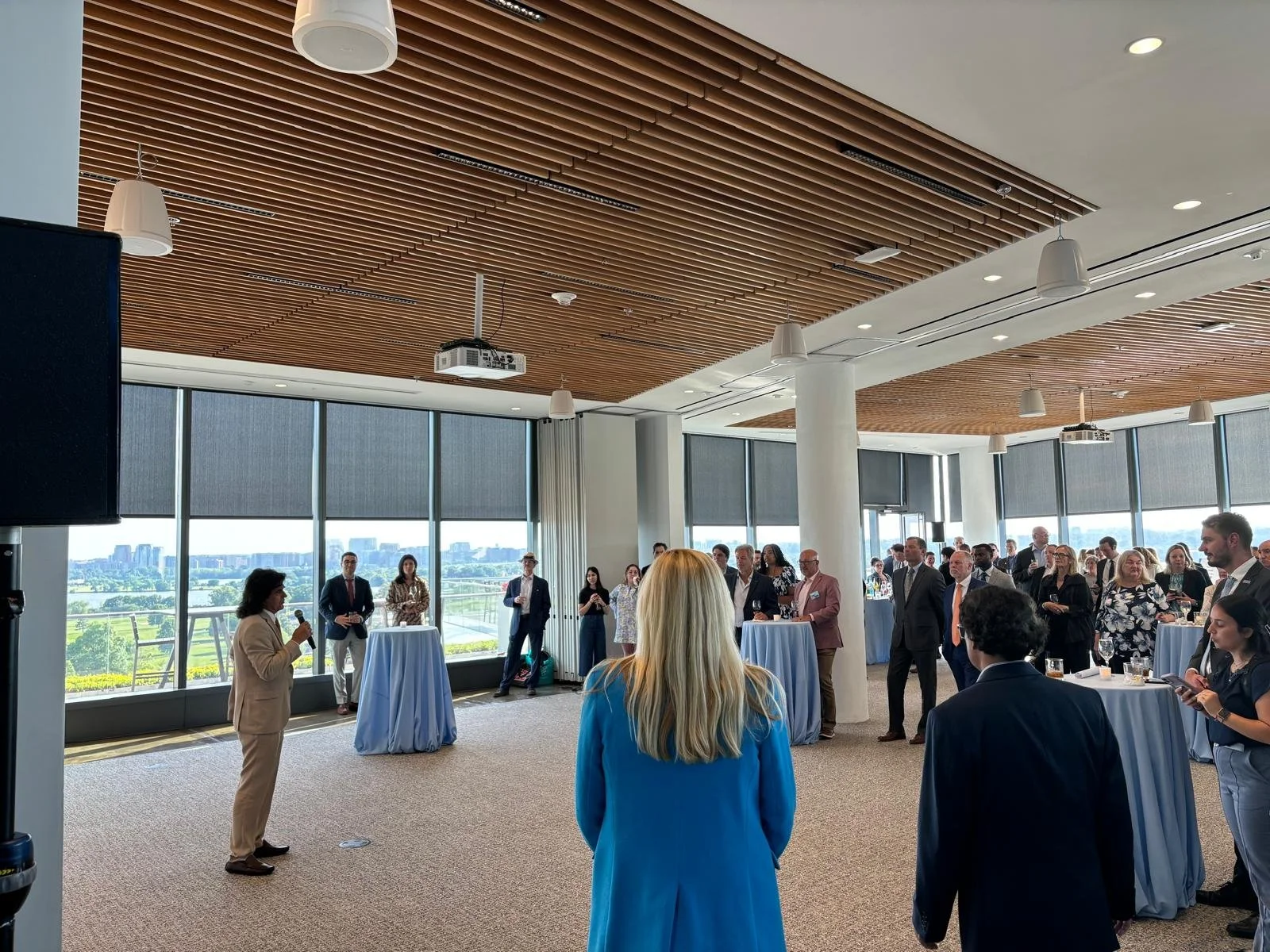 a group of people at a corporate event in a modern conference room with large windows