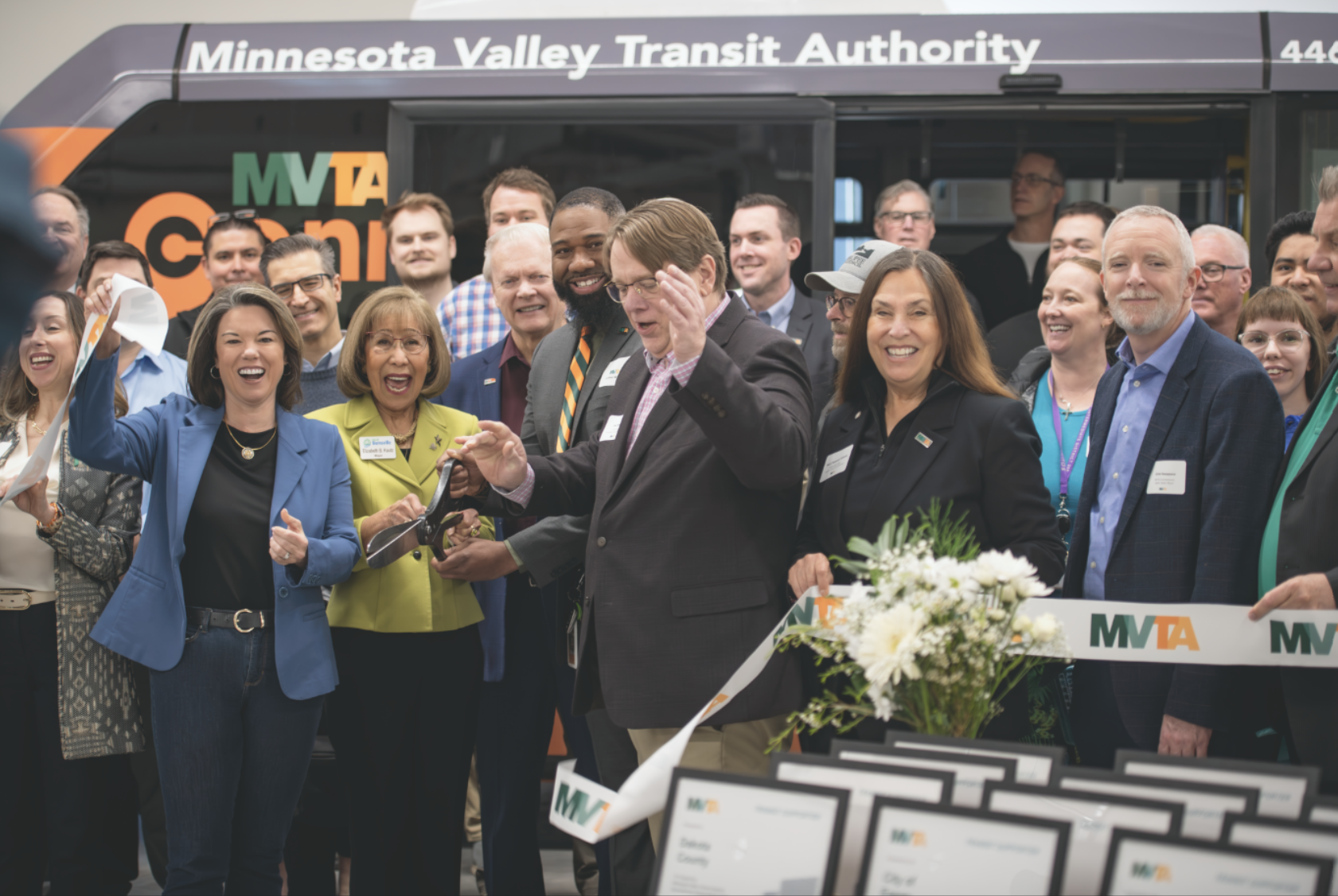 MVTA officials cut a ribbon on the Burnsville bus garage while standing in front of a bus