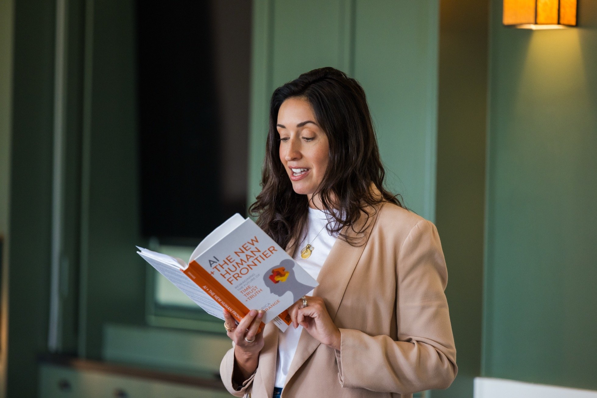 Woman reading a book titled 'AI: The New Human Frontier' in an indoor setting.