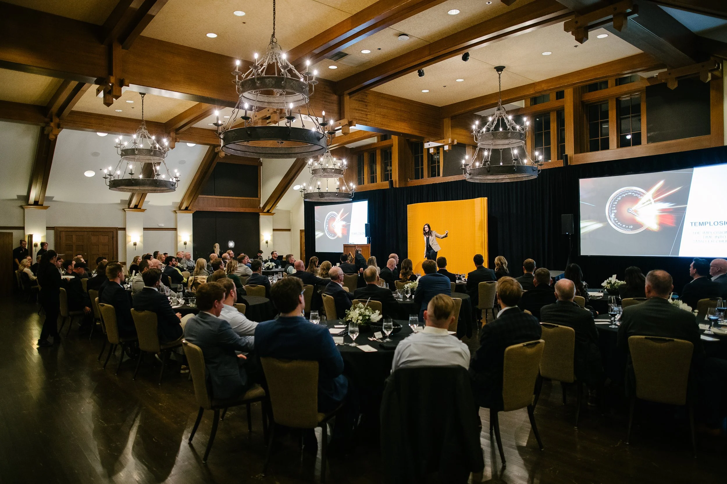 Erica Orange delivering a keynote to a full ballroom audience