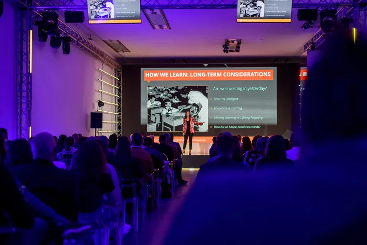 Erica on stage presenting to a conference audience