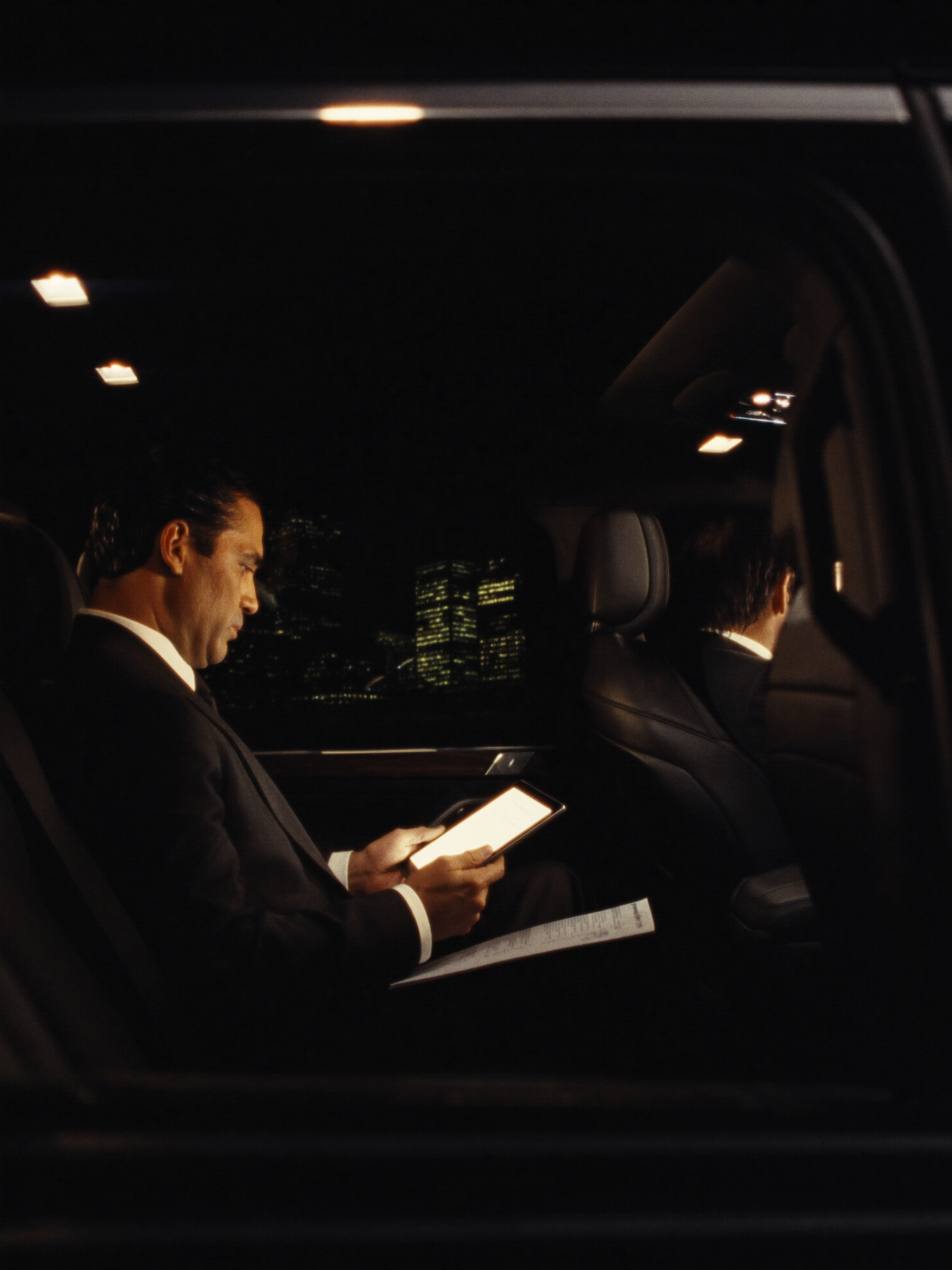 client in suite sitting inside black suv