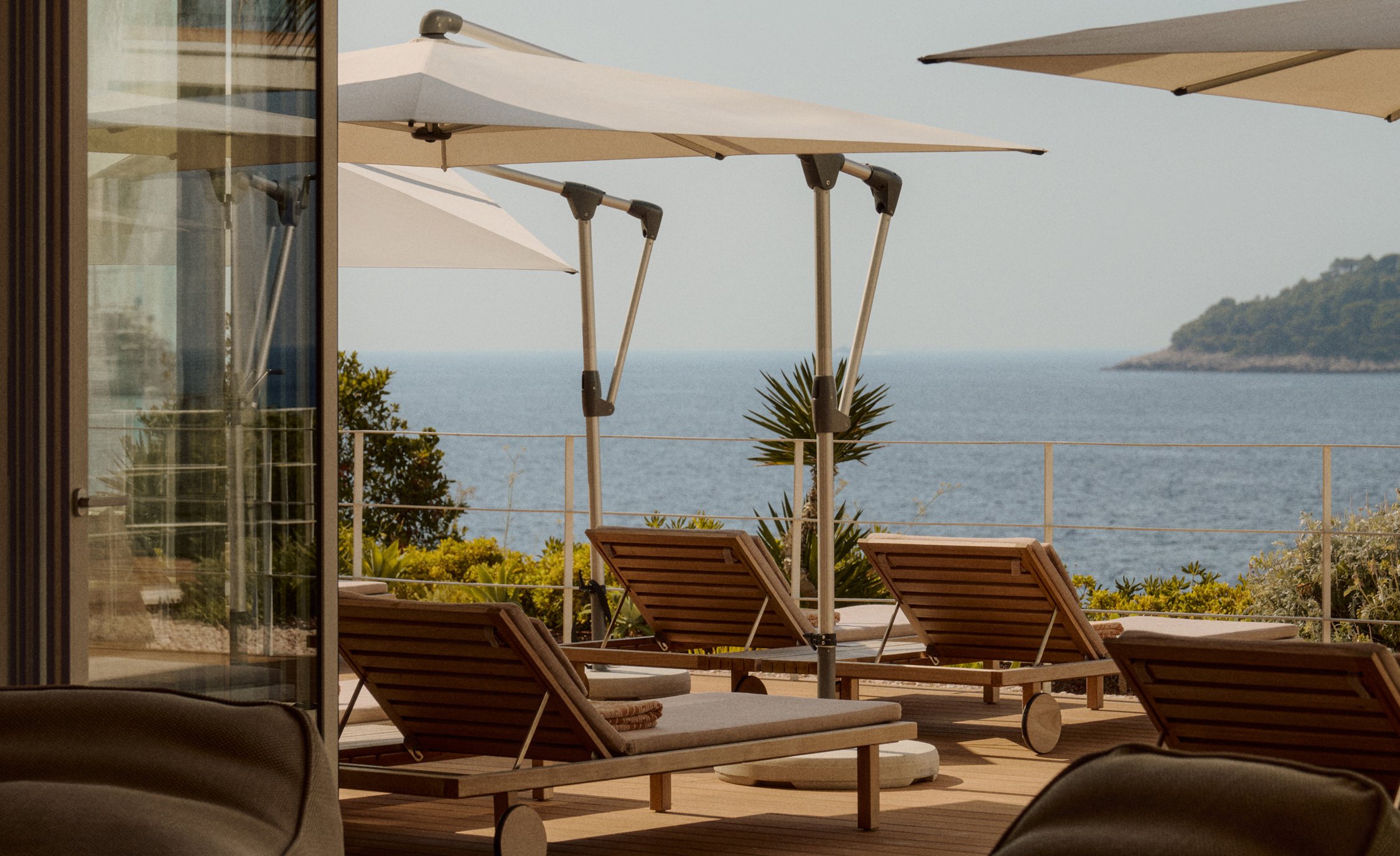 Shaded terrace with sun loungers and umbrellas overlooking the Adriatic at Villa Dubrovnik