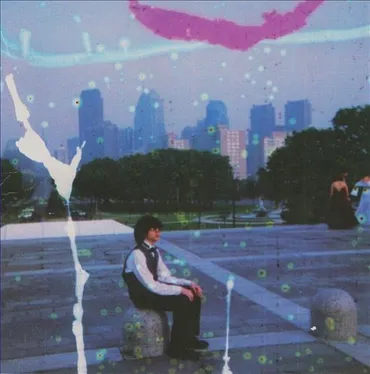 A young person sitting on a concrete block in a park with city skyline in the background, overlaid with digital effects like colorful streaks and splatters. Album art.