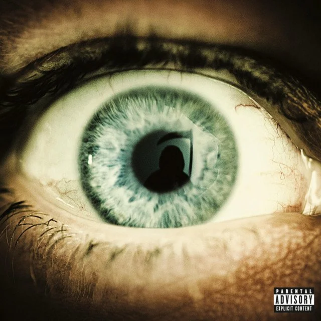 Close-up of a human eye with a reflection of a person's silhouette in the pupil. Album artwork.