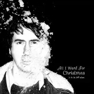 A black-and-white photo of a young man with short dark hair, with part of his face covered by snow. Text on the image reads, 'All I Want For Christmas is to be left alone.' Album art.