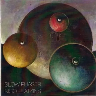 Abstract artwork with three large circles resembling planets, featuring eyes, with a dark background and the text 'Slow Phaser Nicole Atkins' in the bottom left corner.