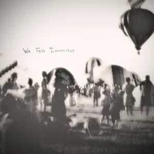 Group of people gathered outdoors with hot air balloons in the sky, some text reads 'We felt Immortal'. Album Art.