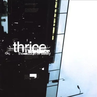 A dark, modern building with illuminated windows and a streetlight, with the word 'thrice' and the phrase 'the illusion of safety' printed in white text on the side. Album Art.