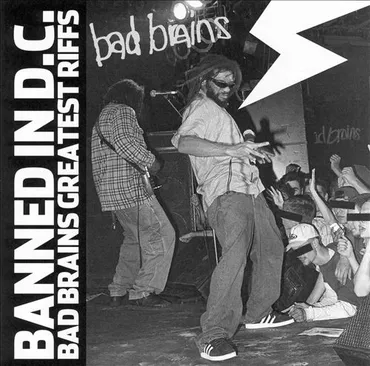 A black and white photo of a band performing on stage with a sign reading 'bad brains' and 'bad brains greatest hits' behind them, with people enjoying the concert in front. Album art.