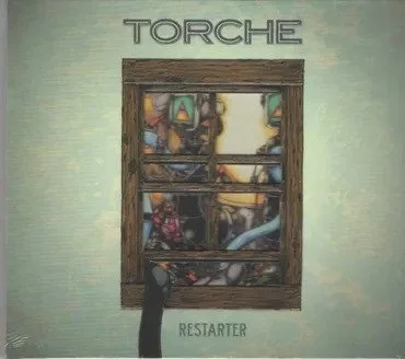 A framed picture of a colorful, abstract dog behind glass, with the word 'TORCHE' above and 'RESTARTER' below, mounted on a light green wall.