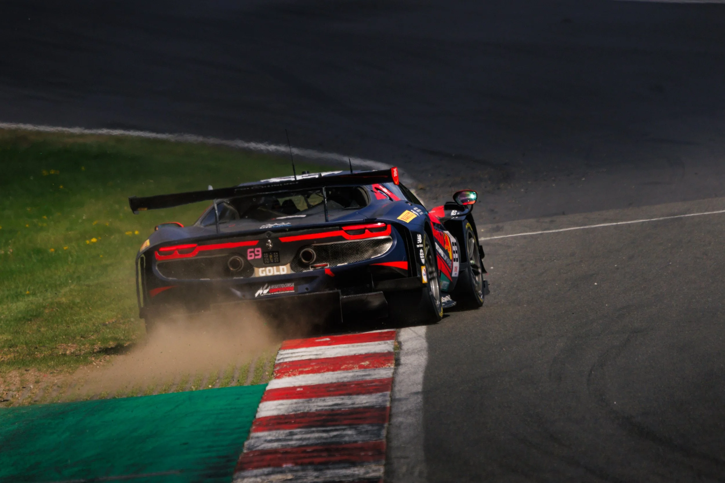 A race car on a track, kicking up dust as it navigates a corner.