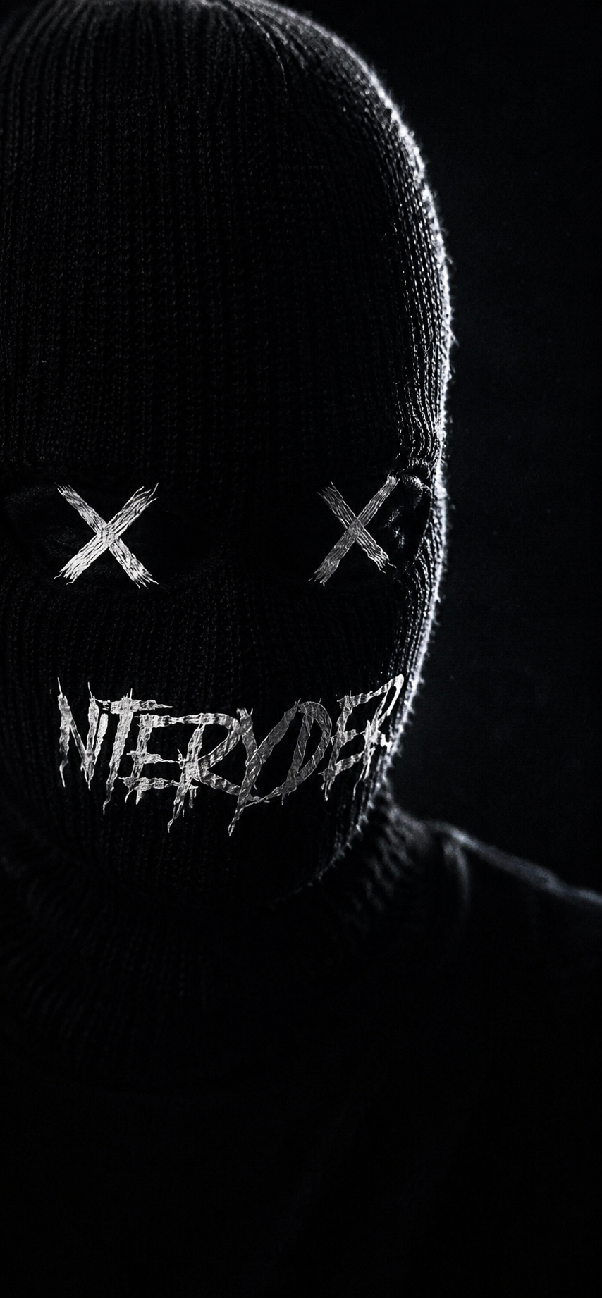 A person wearing a black ski mask with stitched X's over the eyes and the word 'VICTIMS' written across the mouth area in white, distressed letters. The background is dark.