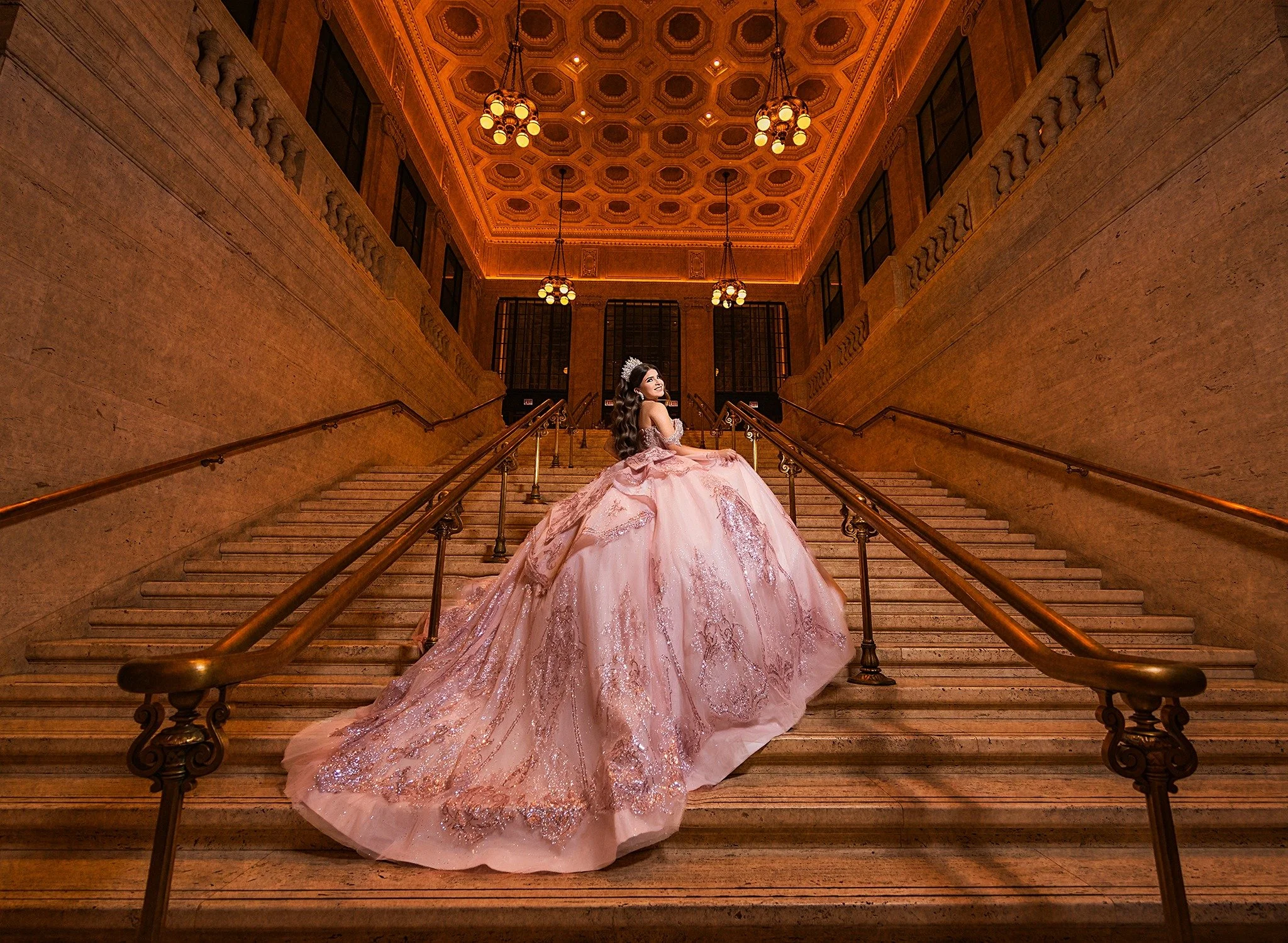 Andrea in a pink quinceañera gown on a grand staircase
