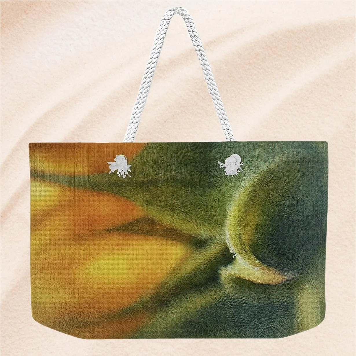 Beach bag with a close-up of a yellow and green flower design, placed on sandy ground.
