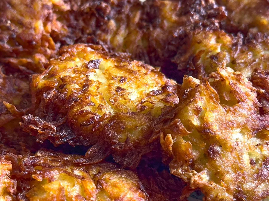 Close-up of crispy, baked fried chicken pieces topped with melted cheese and onions.