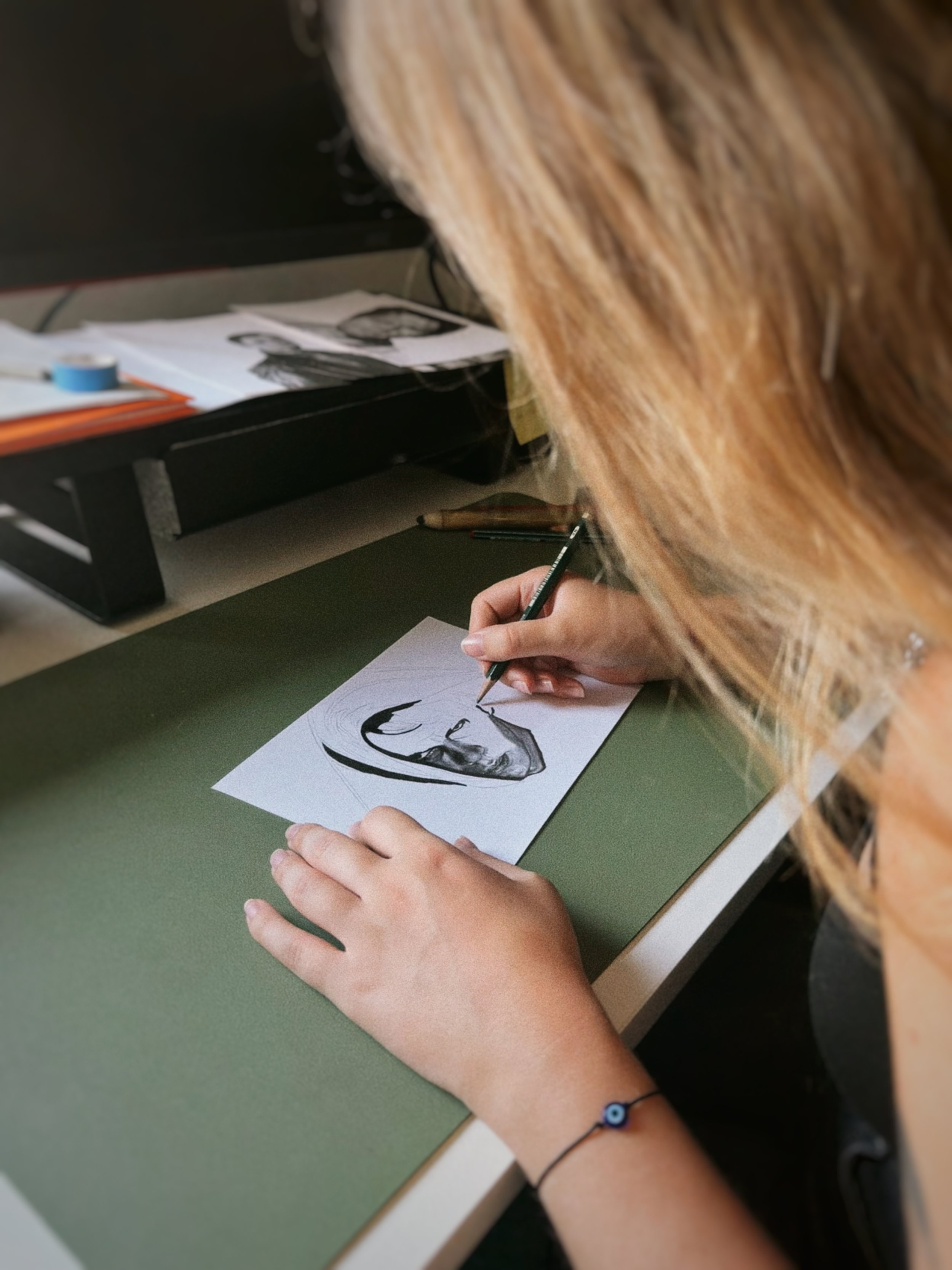 Professional illustrator creating a realistic graphite portrait in her art studio.