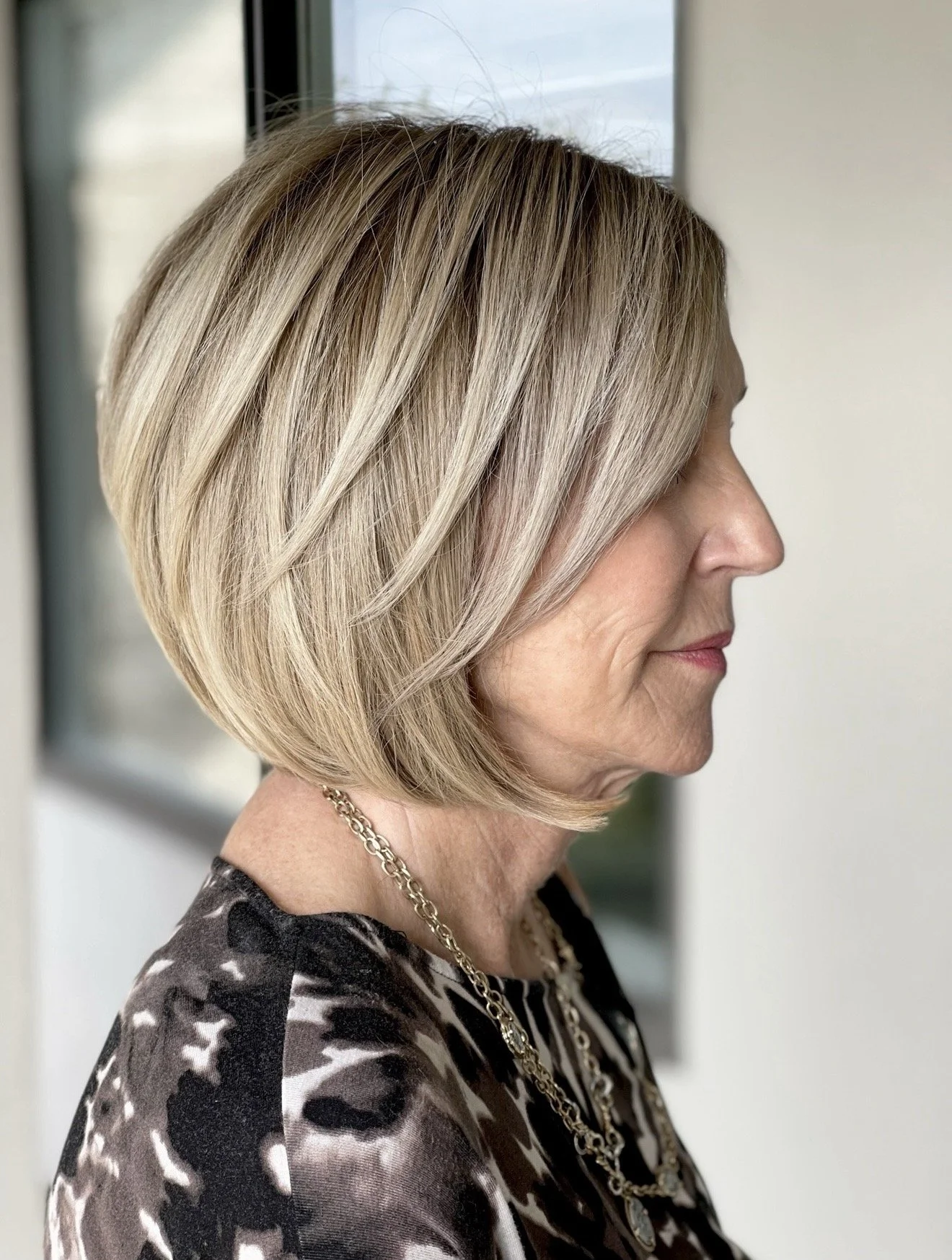 Short precision layered haircut with soft dimensional blonde highlights by Janet Biggers.