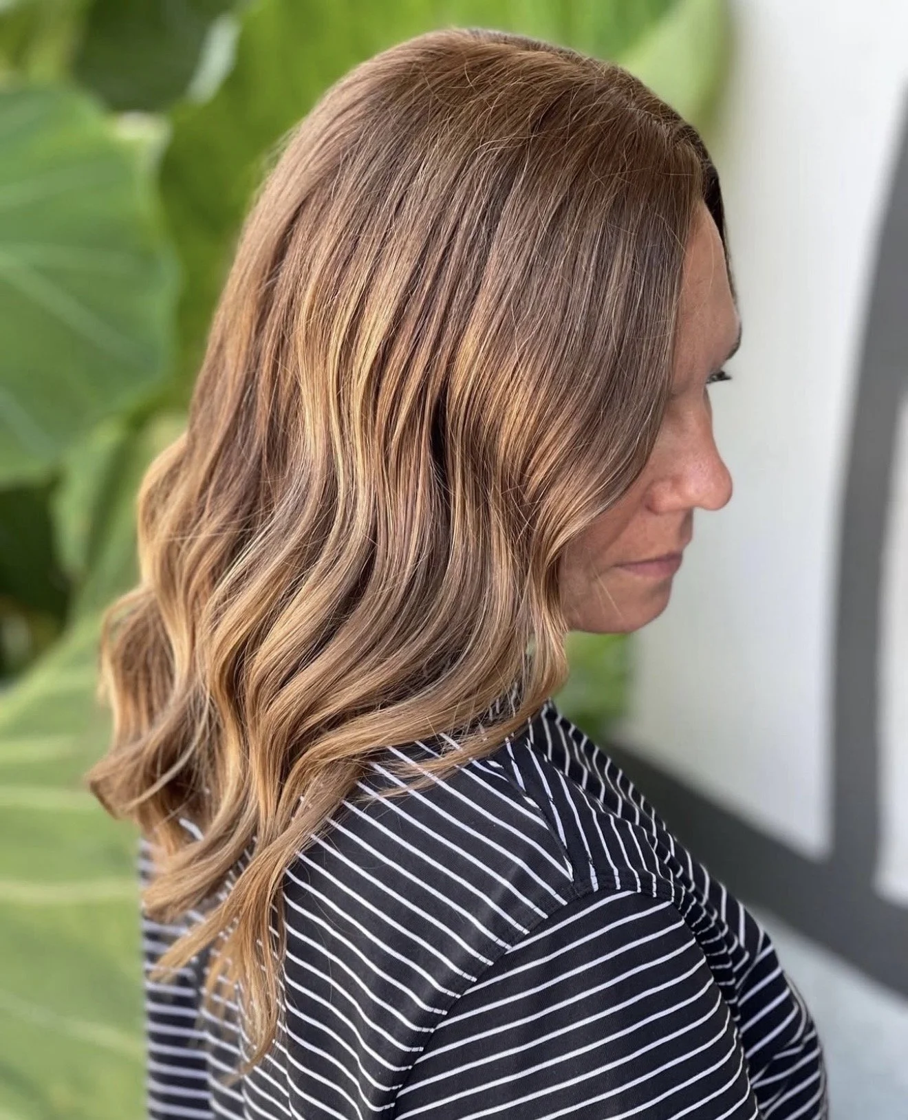 Soft lived-in brunette balayage with caramel highlights and loose waves. 