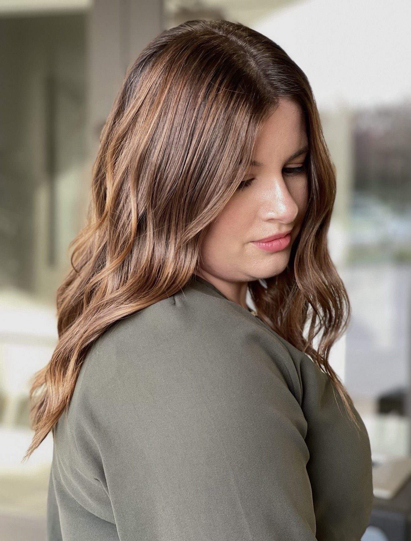 Soft dimensional brunette color with subtle highlights and loose waves.