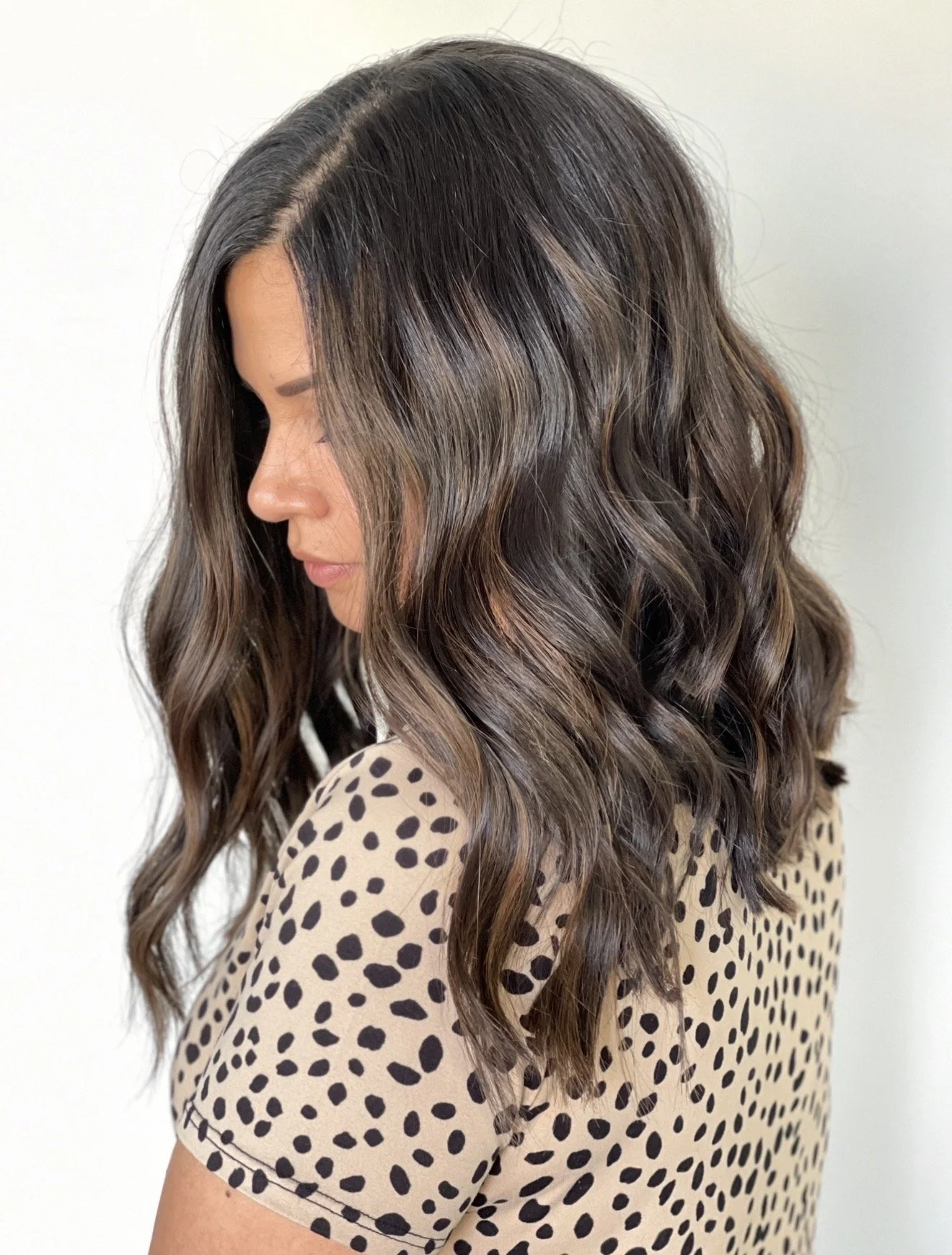 Dimensional brunette color with lived-in balayage and soft waves by Janet Biggers 