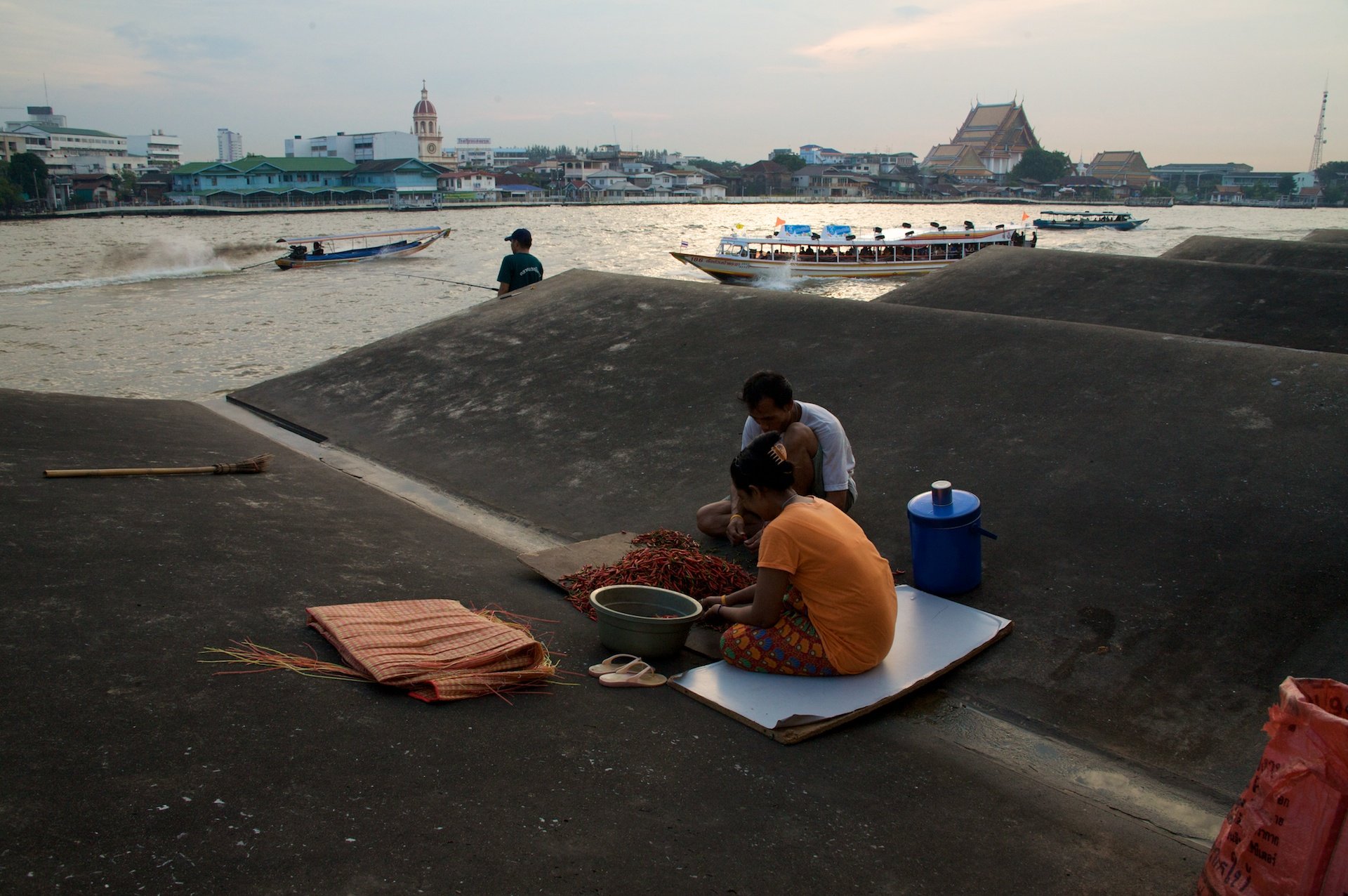 Sorting chilis on warehouse rooftop, Bangkok.