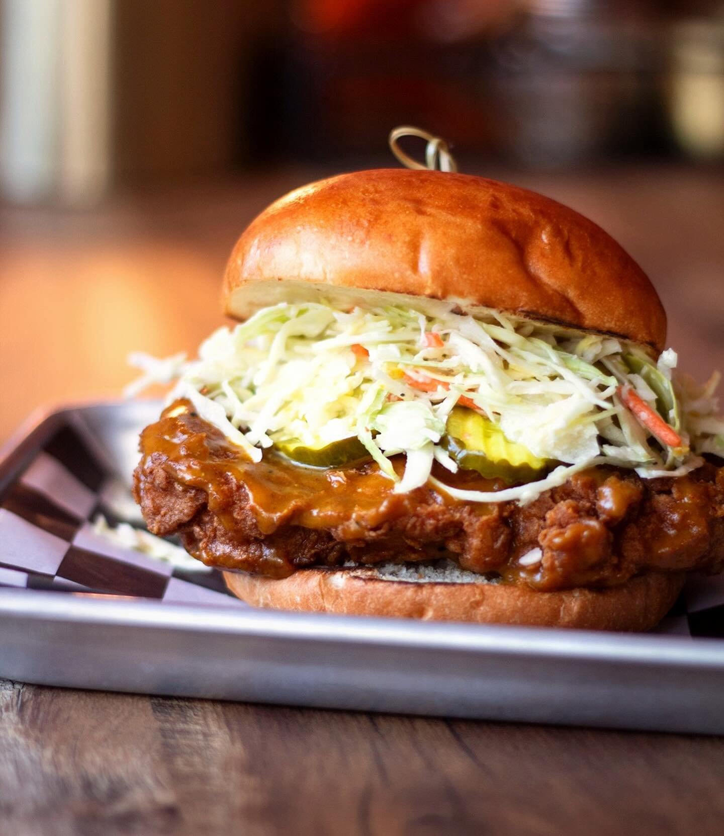 You shoveled. You scraped. You questioned your life choices.
Now eat.

THE CAROLINA GOLD 🌟 Sweet. Tangy. Sticky as hell.

A crispy fried thigh glazed in our house Carolina Gold BBQ, stacked with sweet pickles and crunchy slaw.

Cabin fever cure. Lim