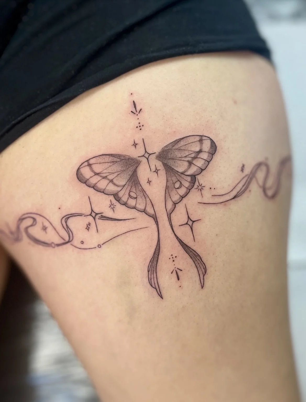 Moth thigh tattoo