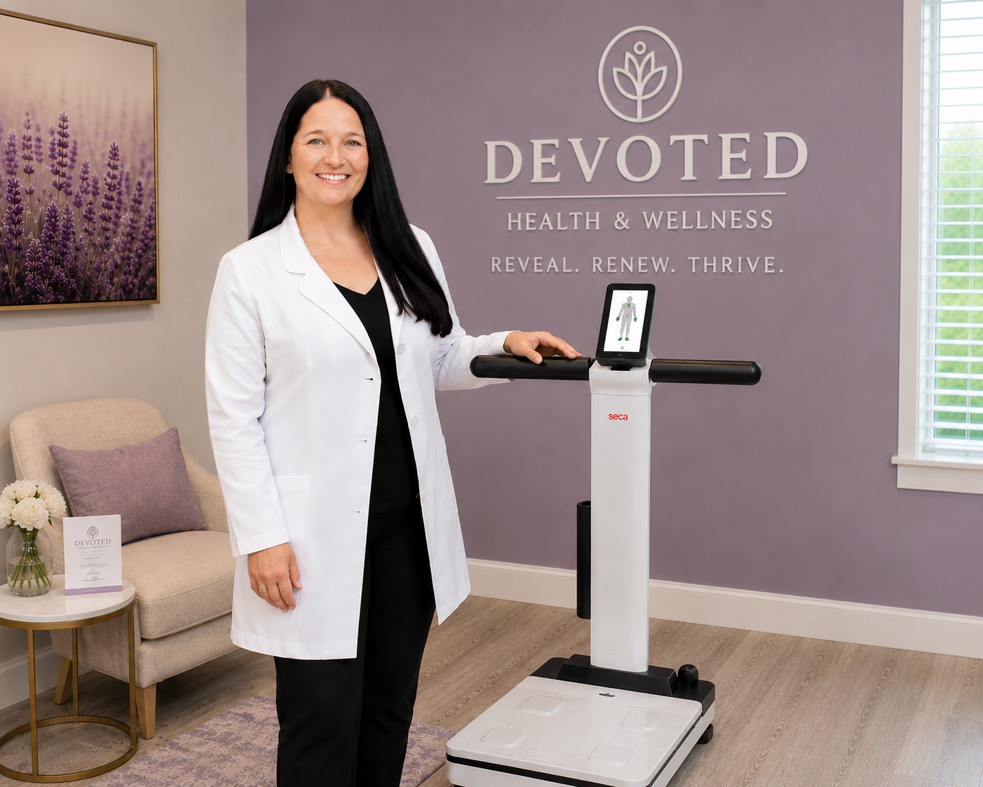 A woman in a white coat standing next to a body analysis scale with a display screen, inside a wellness clinic named Devoted Health & Wellness.