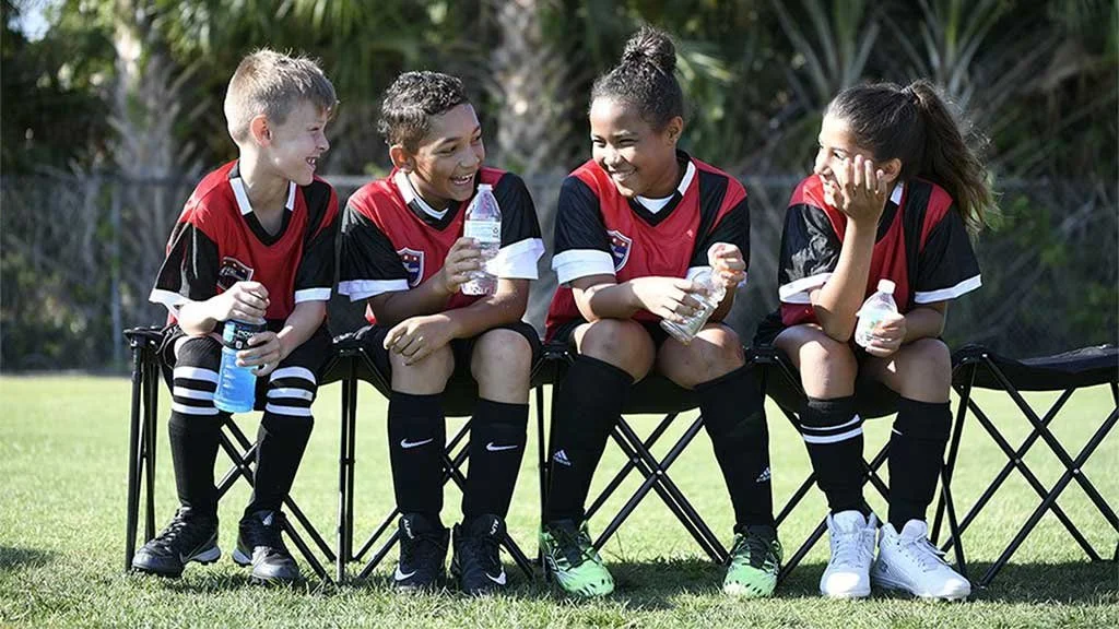 i9-Sports-Soccer-Kids-Laughing-on-sideline-1-TABLET.jpg