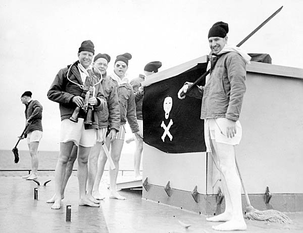 The Davy Jones Lookout Watch posted atop Turret II. Uniform for lookouts, skivvie trunks, foul weather jackets, scarves, watch caps and no footgear. Chaplain, CDR Wells, 2nd from left in the group of three